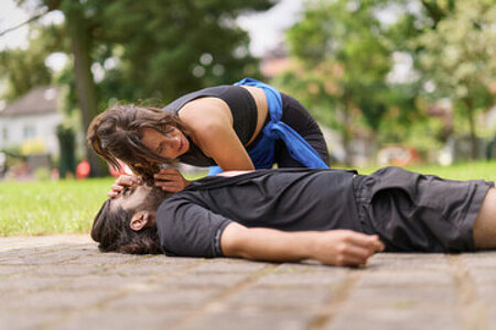 Erste Hilfe Situation. Der Mann ist beim Joggen zusammengebrochen. Die Frau leistet eine Atemspende