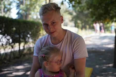 Steven Decker hält ein Kind der DRK-Kita Pusteblume im Arm.