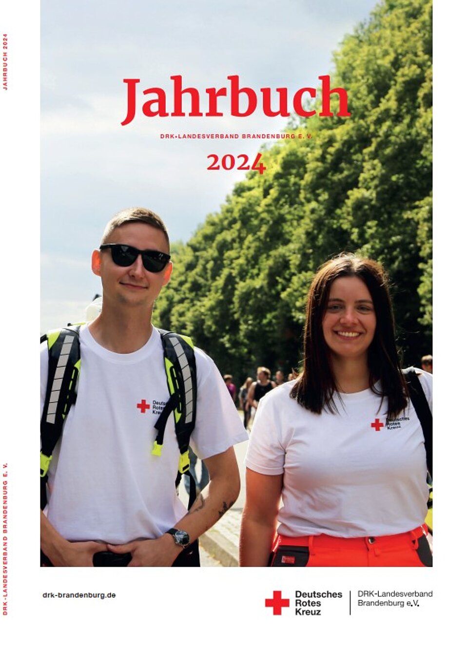 Das Cover des Jahrbuchs 2024 des DRK-Landesverbands Brandenburg e.V. zeigt zwei Ehrenamtliche im Einsatz