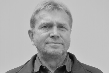 Das Bild in schwarz-weiß zeigt das Porträt eines Mannes in mittlerem Alter, der freundlich in die Kamera lächelt.