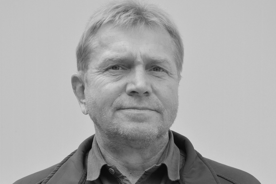 Das Bild in schwarz-weiß zeigt das Porträt eines Mannes in mittlerem Alter, der freundlich in die Kamera lächelt.