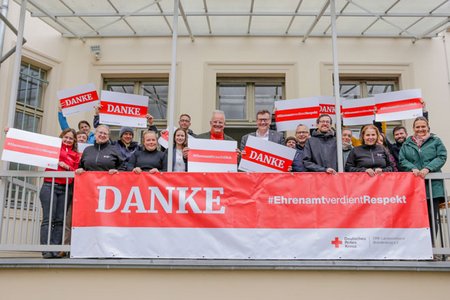 Gruppenfoto DRK-Mitarbeitende der Landesgeschäftsstelle halten Danke Plakate hoch