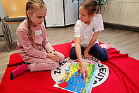 Zwei Mädchen spielen zusammen auf einer DRK-Decke