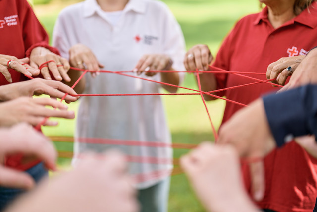 Symbolbild Vernetzung, Netzwerk beim DRK. Hände sind mit einer Schnur untereinander verbunden